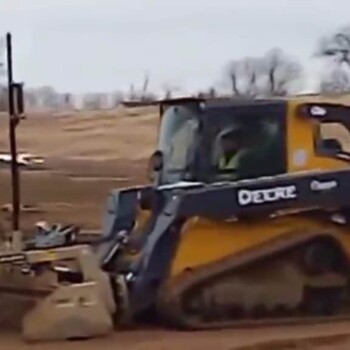 John Deere tractor driving down dirt path