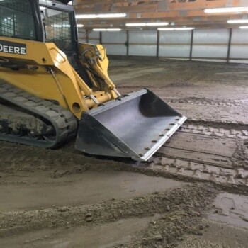 Tractor leveling riding surface of horse arena